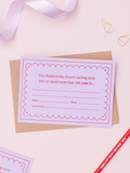 A Lavender Mother's Day Gift Of Time Voucher with red foil lettering, placed on top of a brown kraft envelope. A lavender ribbon, and red pencil is visible in the background on a pink surface.